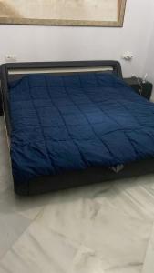 a bed with a blue comforter in a room at Habitacion privada en un dúplex in Seville