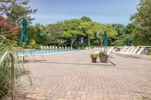 a patio with chairs and umbrellas and a pool at Stunning Townhouse w Tennis & Pool in Southampton