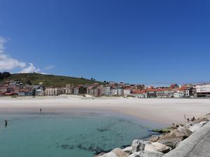 a view of a beach with buildings in the background at Apartamento Mar-Azul in Laxe
