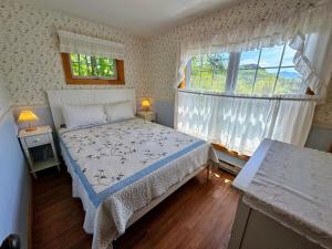 a bedroom with a bed and a large window at 11G Quintessential New Engalnd Cottage with Fantastic Views! in Sugar Hill