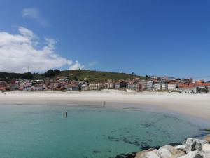 a person standing in the water at the beach at Apartamento Mar-Azul in Laxe +5 photos