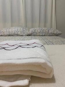 a pile of towels sitting on a bed at Apartamento Cidade Nova in Paragominas