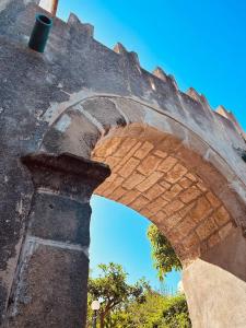 een boog in een bakstenen gebouw met een blauwe lucht bij Villa Tiche in Cefalù