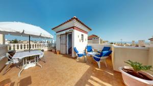 a balcony with a table and chairs and an umbrella at El Olivo and Brisas Beach house in Gran Alacant
