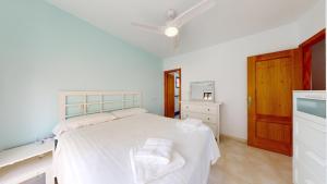 a bedroom with a white bed and a wooden door at El Olivo and Brisas Beach house in Gran Alacant +31 photos