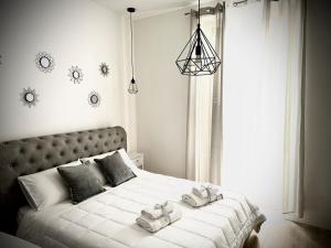 une chambre avec un grand lit blanc avec des serviettes dessus dans l'établissement Affittacamere Palermo Pirri, à Palerme