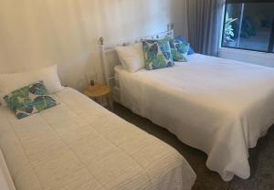 twee bedden naast elkaar in een kamer bij Sunrise on Main in Tairua
