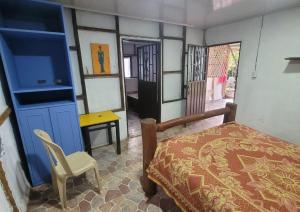a bedroom with a bed and a table and a chair at Finca La Rivera in San Agustín