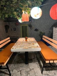 une table et deux bancs avec une table et des chaises dans l'établissement Apartment Smokva, à Trogir