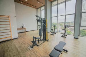 un gimnasio con cintas de correr y equipos de ejercicio en una sala con ventanas en 717 - Rentaqui Studio Elegance Butanta, en São Paulo