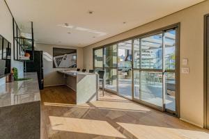 Una oficina con una gran puerta de vidrio y un escritorio. en 717 - Rentaqui Studio Elegance Butanta, en São Paulo
