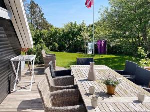 a patio with a wooden table and chairs on a deck at Holiday home Struer XXIX in Struer