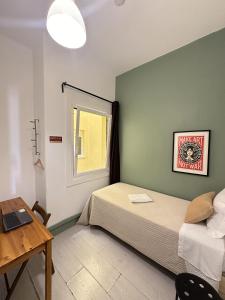 Schlafzimmer mit einem Bett und einem Schreibtisch mit einem Laptop in der Unterkunft Ey Lisbon GuestHouse in Lissabon