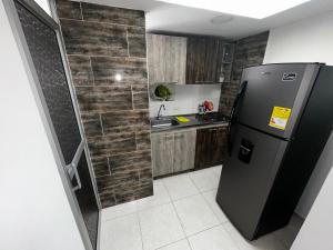 マニサレスにあるViveros 2 hab moderno, tranquilo y familiar.のタイル張りの壁、キッチン(冷蔵庫付) +6枚の写真