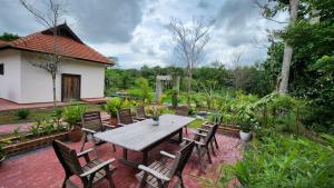 a wooden table and chairs on a brick patio at Mawarvilla jb in Johor Bahru