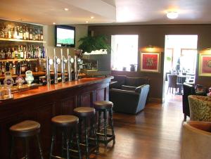 una barra en un restaurante con taburetes en Bridge of Orchy Hotel, en Bridge of Orchy