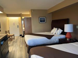 a hotel room with two beds and a desk at Americas Best Value Inn Kalispell in Kalispell