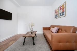 a living room with a brown couch and a table at Beautiful Flat Near the Center 11 min by tube in London