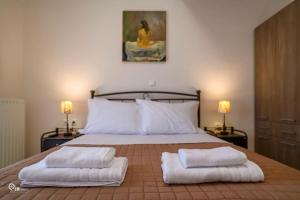 a bedroom with a bed with two towels on it at Luxury Villa King George in Nea Makri in Nea Makri