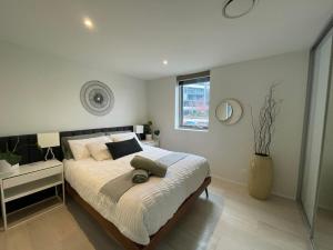 a bedroom with a large bed and a vase at Lakeview Luxe - EV charger, Pool, Gym, Location + in Kingston 