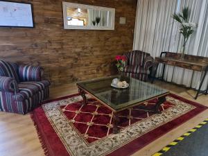 ein Wohnzimmer mit 2 Stühlen und einem Couchtisch in der Unterkunft Hotel Sonetto in Santiago