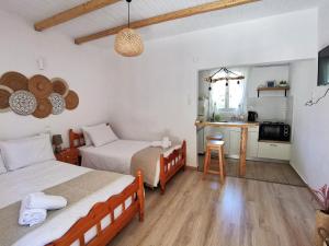 a small room with two beds and a kitchen at Sotiria Apartments in Kokkino Nero