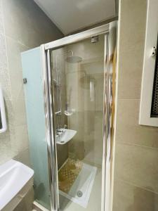a glass shower in a bathroom with a sink at Zayatine RDC in Tunis