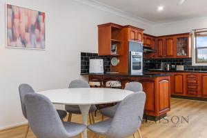 cocina con mesa blanca y sillas en Home in Waratah, en Lambton