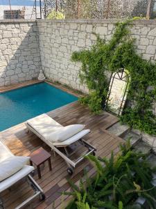 a deck with two lounge chairs and a swimming pool at 9 Alacati Boutique Hotel in Alacati