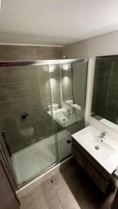 a bathroom with two sinks and a glass shower at Dpto nuevo Reñaca gran terraza in Viña del Mar