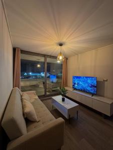 sala de estar con sofá y TV de pantalla plana en Dpto nuevo Reñaca gran terraza, en Viña del Mar