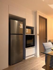 a kitchen with a stainless steel refrigerator and a microwave at Dpto nuevo Reñaca gran terraza in Viña del Mar