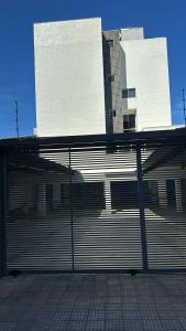 una puerta metálica frente a un edificio en LOFT ACONCHEGANTE COM ALEXA, en Belo Horizonte