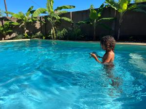 - un enfant en bas âge dans la piscine dans l'établissement Binta Boutique Hotel, à Nungwi