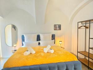 基彭海姆Design I Gewölbe I sanierter Pferdestall I EuropaPark I Boxspring I Nespresso I Terrasse I Parkplatz的一间卧室配有一张大黄床和2条毛巾