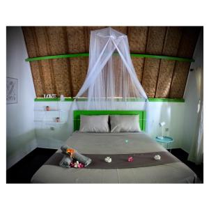 ein Schlafzimmer mit einem Himmelbett in der Unterkunft Kaktus bungalow 4 in Gili Air
