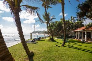 a view of the beach from a resort with palm trees at Mosvold Villa in Ahangama