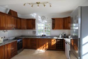 a kitchen with wooden cabinets and a window at Casa vista Arrabida in Cotovia