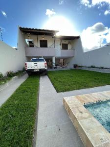 un'auto parcheggiata di fronte a una casa di Casa por temporada Praia de Atalaia ad Aracaju