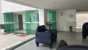 a lobby with a chair and a glass wall at Mar de Ponta Negra in Natal +59 photos