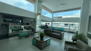 a large living room with couches and chairs in a building at Mar de Ponta Negra in Natal