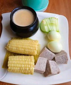 un plato de comida con maíz y una taza de café en MINAZI BEACH BUNGALOWS, en Nungwi