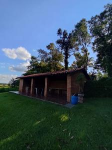 uma pequena casa de tijolos com um quintal relvado em Holambra e a natureza rural em Holambra