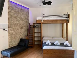 a bedroom with two bunk beds and a chair at LUXURY APARTMENTS CHINITAS 11 in Málaga