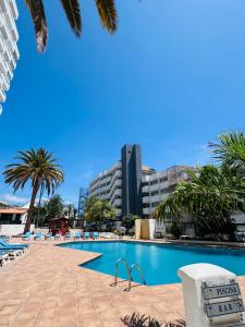a swimming pool with a building in the background at Jameo de agua, las americas studio sea view in Playa Fañabe