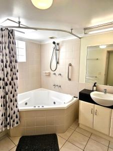 y baño con bañera y lavamanos. en Premium 3 bedroom River Front Location, en Rockhampton