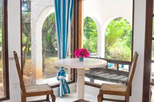 einen Tisch und Stühle in einem Zimmer mit Fenster in der Unterkunft Shoreline Serenity in Malindi in Malindi