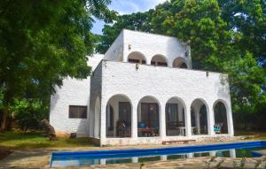 ein weißes Gebäude mit einem Pool davor in der Unterkunft Shoreline Serenity in Malindi in Malindi