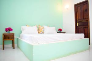 Bett mit weißer Bettwäsche und Kissen in einem Zimmer in der Unterkunft Shoreline Serenity in Malindi in Malindi