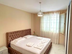 a bedroom with a bed with two towels on it at Green Residence by the beach in Golem +19 photos